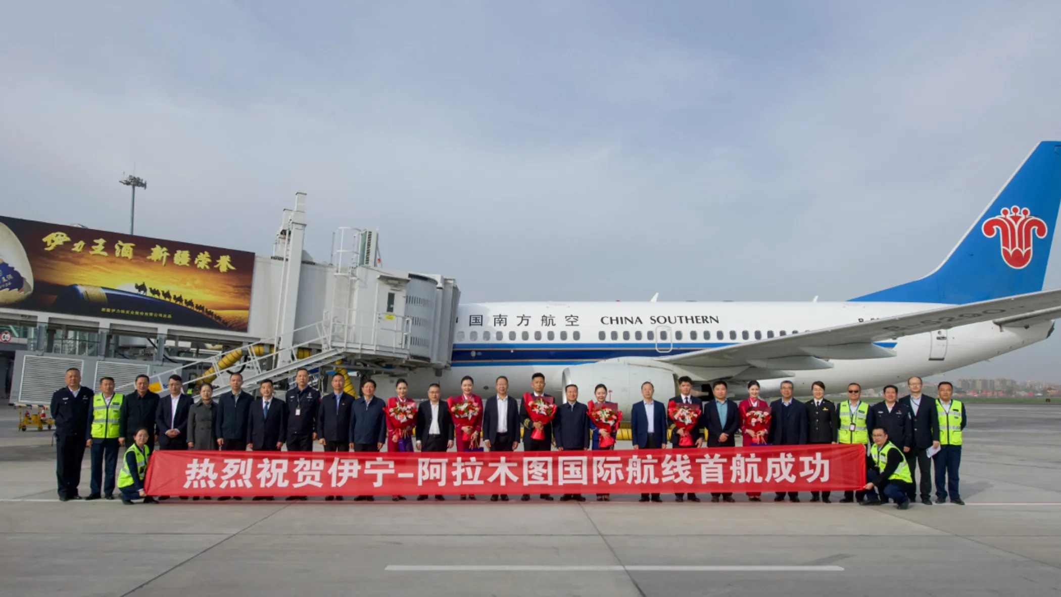 Banner reads, 'Warm congratulations on the success of the first flight of the Yining–Almaty international route' (source: ccaonline.cn)